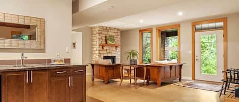 Kitchen with dishwasher and living room with entrance way. Heated floors throughout the suite keep it cosy in the winter.