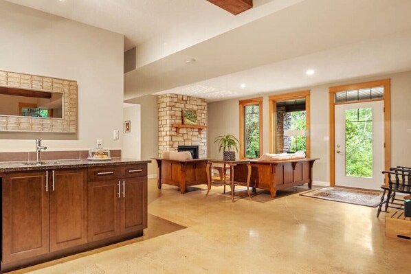 Kitchen with dishwasher and living room with entrance way. Heated floors throughout the suite keep it cosy in the winter.