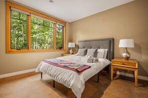Bedroom one with queen sized bed and walk in closet.