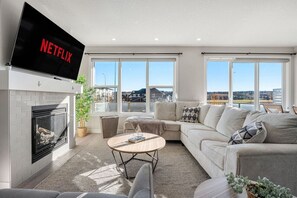Cozy, luxurious & modern living room with a placce for everyone to connect, 65" Smart TV with Netflix shows, movies and more!