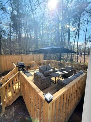 Large deck with furniture and umbrella. 
