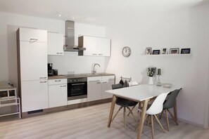 Fitted kitchen with ceramic hob, oven, refrigerator with freezer compartment