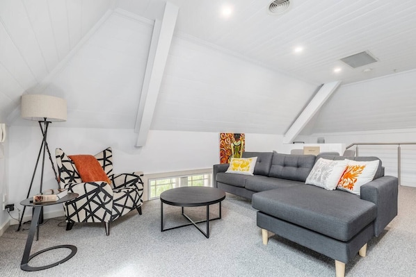 A sofa and chaise provide ample space to kick back with some TV, while an armchair and floor lamp offer a cosy reading corner. 
