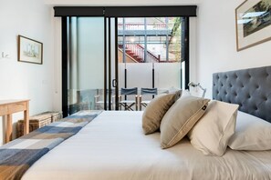 The bedroom is fitted with a comfortable queen bed and benefits from direct access to a second balcony.