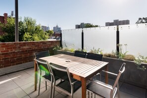 A six-seater table on the balcony offers the perfect setting to dine alfresco, with festoon lights and glimpses of the Melbourne skyline.