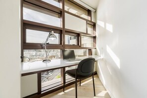  Enjoy a bright, dedicated work space with a desk and chair placed up against the floor-to-ceiling windows.