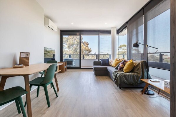 The living room extends straight to the balcony, filling the space in an abundance of natural light.
