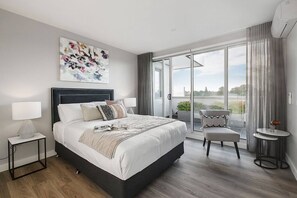 Master bedroom offers a luxurious queen bed with stylish velvet bed head, private access to the outdoor terrace and en-suite bathroom featuring back-lit mirror, bath and heated towel racks