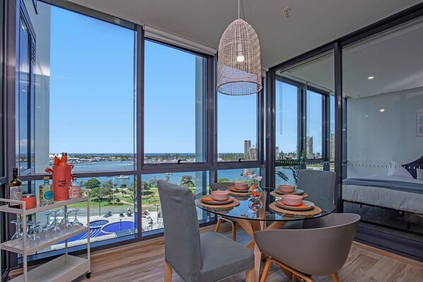 An enclosed balcony has been transformed into a dedicated dining room, framing stunning water views.
