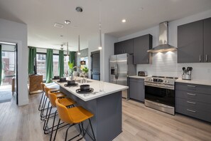 Fully equipped kitchen stocked with your basic cooking essentials, stainless steel appliances, and breakfast bar seating.