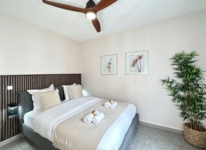 Spacious bedroom with a queen-size bed, ceiling fan, and ample storage