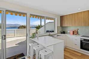 Cook up a storm in this fully-equipped kitchen, where sleek stone benchtops meet top-of-the-line appliances.