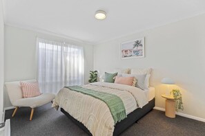 The second bedroom offers a chic retreat with a queen-sized bed and ample storage. This room provides a serene space to rest and recharge. 