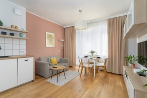 An open-plan living and dining area with warm tones, a round table, and modern furniture.

