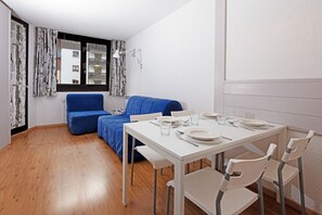 Living area with dining table and two sofa beds, single and double. 