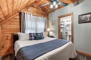 King bed located in the loft with adjoining bathroom and shower.