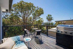 Glistening water views from the balcony make this a picturesque outdoor retreat, with a seating area and a BBQ.
