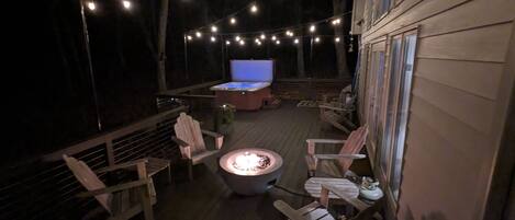 Large deck with salt water hot tub, firepit, dining area, and Weber gas grill.