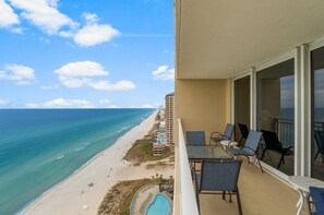 Large balcony with couch, 4 chairs, & small table