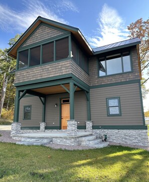 Second floor living space above garage includes large screened in porch.