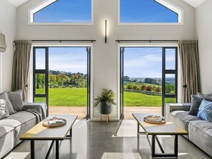 A seating area seamlessly extends from the kitchen under expansive gable ceilings, filling the space with abundant natural light.
