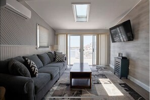 Living room with cable television and access to rear deck