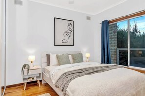  The upstairs primary bedroom features a queen-size bed as well as a private balcony where guests can enjoy a peaceful morning cuppa. 
