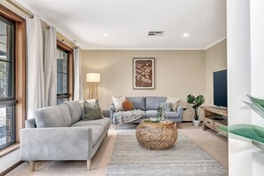 Spread out in the formal living room, with plush sofa seating and a large central TV.
