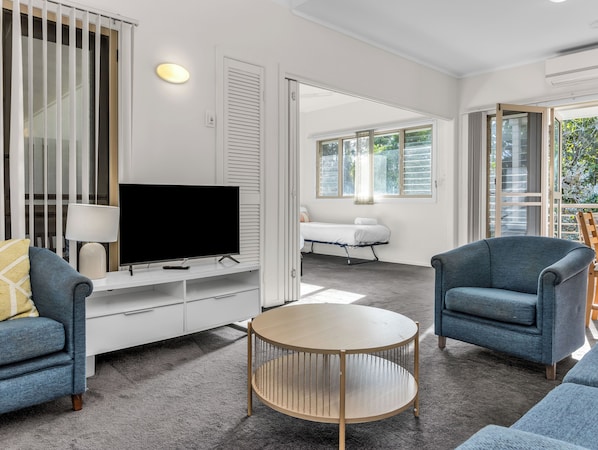 Settle into the cozy living room with plush seating, soft lighting, and a flat-screen TV for your entertainment.