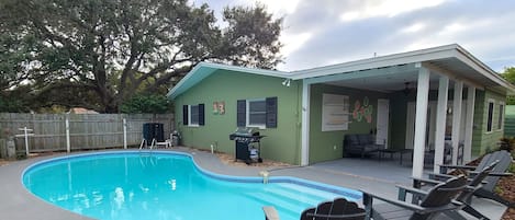 Beautiful heated pool with stylish lounge chairs and BBQ.