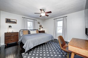 Master with king bed, two dressers, small closet, desk & chair, & 55-inch 4K TV.