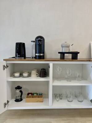 Coffee bar equipped with Nespresso machine, electric kettle, & French press