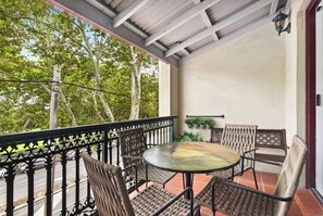 The living area extends to a balcony, overlooking the leafy neighbourhood below. This is an idyllic spot to enjoy a meal outdoors.