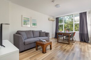 The living room is complete with a two seater lounge that doubles as a pull out couch and flat screen TV