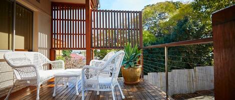 An oversized deck is dressed with classic outdoor furniture for you to bask in the sunshine or enjoy an alfreso meal.