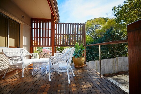 An oversized deck is dressed with classic outdoor furniture for you to bask in the sunshine or enjoy an alfreso meal.