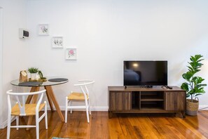 There is a flat screen TV for your entertainment needs and a glass topped dining table set for two, perfect for meals at home.