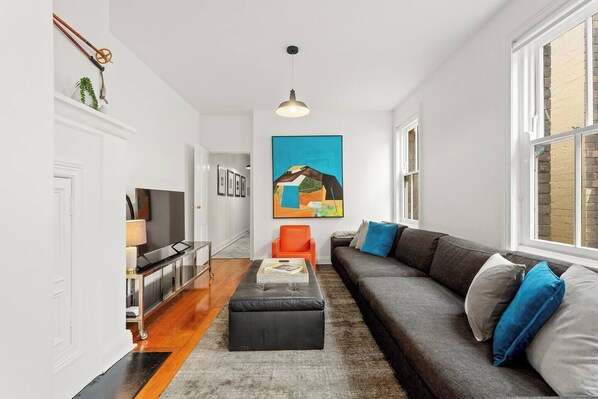 The apartment has a cosy living area with a comfortable sofa and smart TV, perfect for relaxing at the end of a busy day. 
