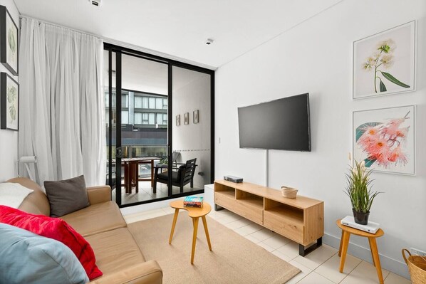 This modern apartment features streamlined interiors with an open plan design that flows to the balcony.