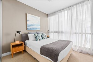 In the bedroom, there is a comfortable bed topped with premium, hotel-style linens. There is wardrobe space for storing your belongings, bed side tables and reading lights.