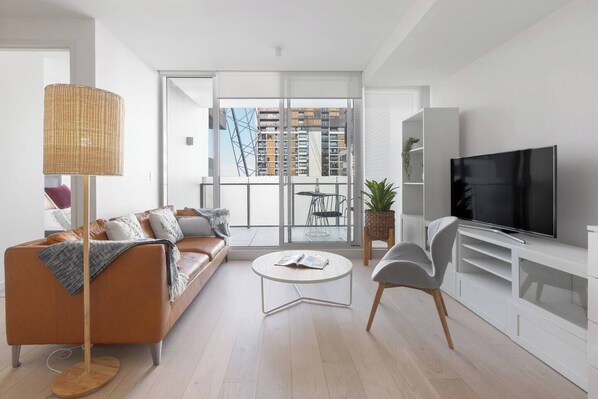 The sunny and spacious living area is replete with a three-seater leather lounge, flat screen TV and access to the first private balcony