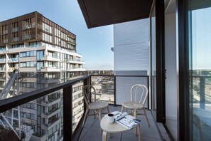 The master bedroom boasts an additional private balcony with outdoor furniture, perfect for enjoying the beautiful Melbourne sunsets