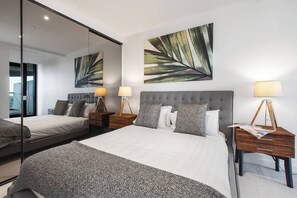 A spacious primary bedroom hosts a queen-size bed and built-in wardrobes, as well as an ensuite bathroom for your privacy.
