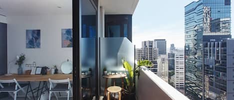 Enjoy a morning coffee on your sunlit private balcony against a backdrop of breathtaking city views 