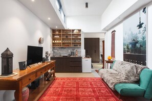 The open plan living and dining area is decorated in exotic, Balinese-inspired furnishing to create a unique home away from home.