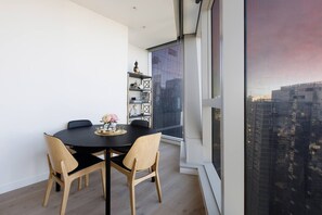 A dining table allows guests to enjoy a meal at home or use it as a dedicated workspace overlooking the city.