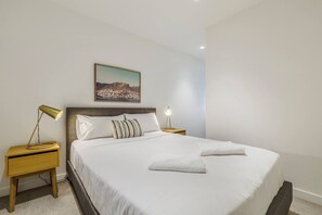 The bedroom is immaculately presented with a sumptuous queen-sized bed, topped in hotel quality linens.