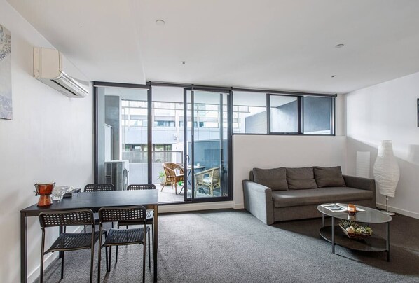 The open-plan kitchen, lounge and dining area includes a four-seater table looking out the balcony.  
