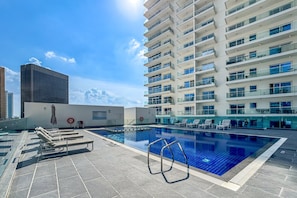 Swimming pool with sun loungers.