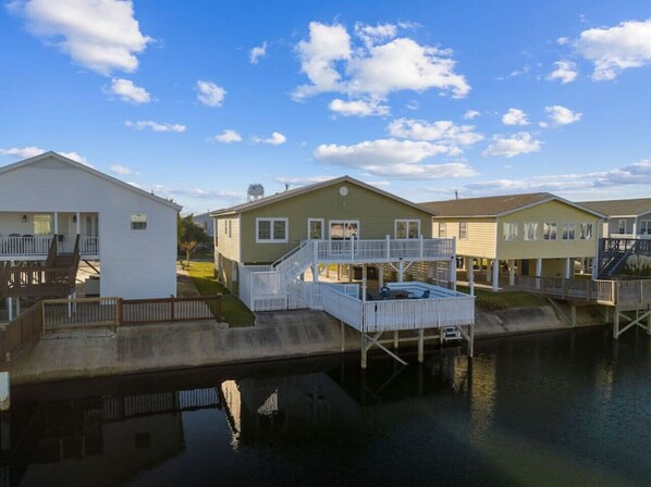 A breathtaking escape: full view of your private getaway, complete with a generous balcony and spacious deck perched right over the water.
